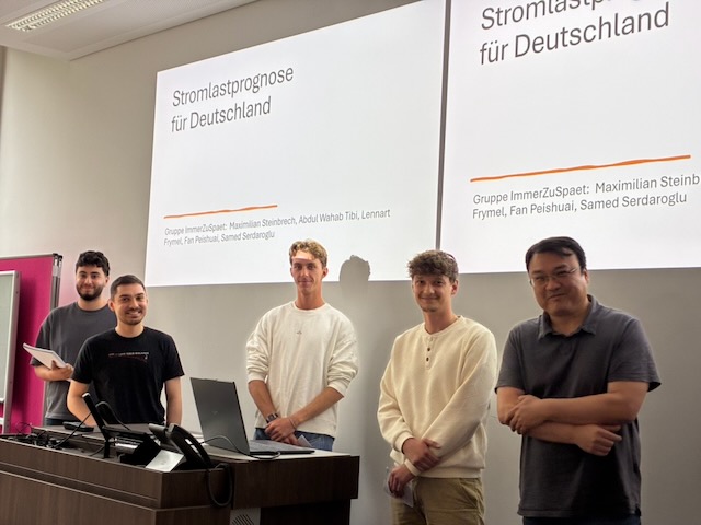 Gruppenfoto eines Teams vor der Leinwand