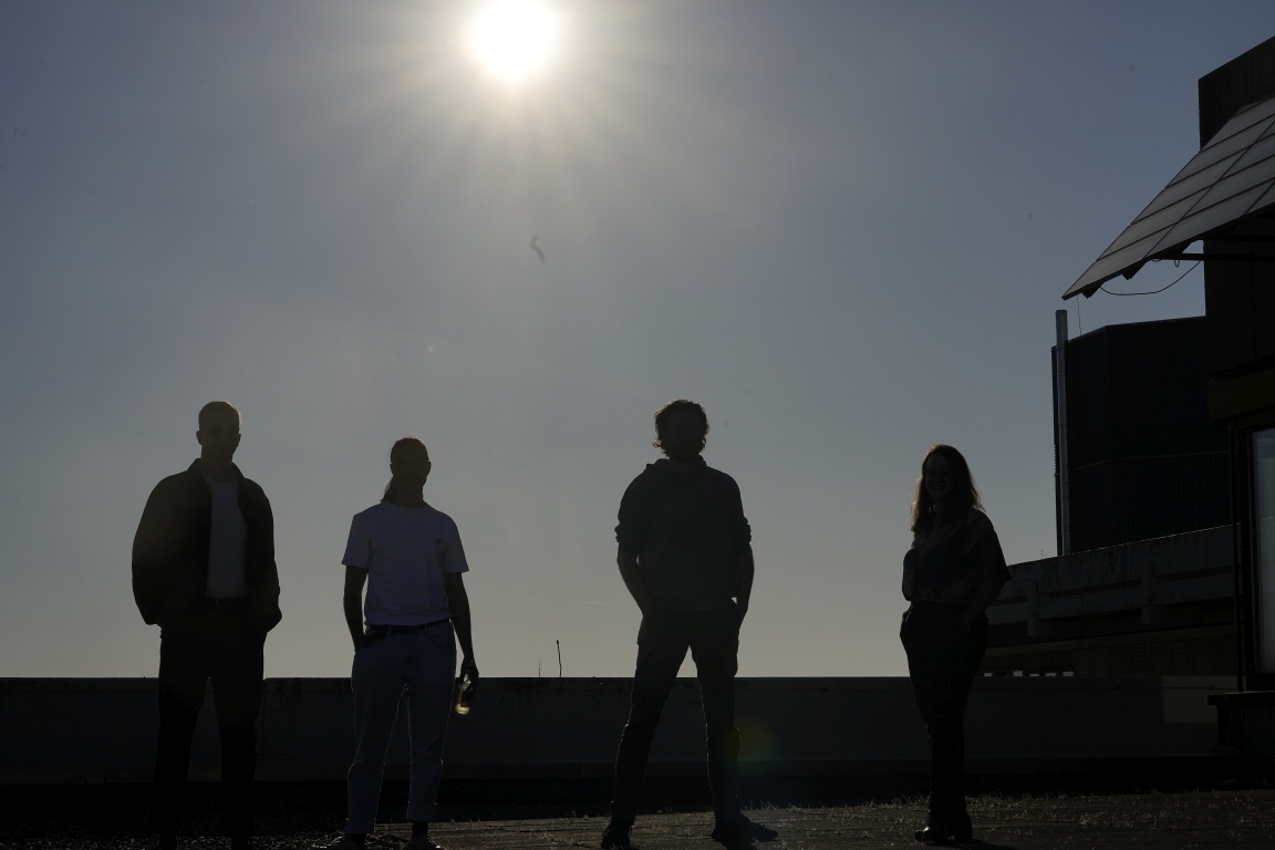 Silhouetten von Personen vor Abendsonne auf einer Dachterrasse