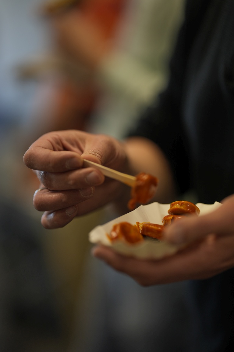 Nahaufnahme einer Currywurst-Portion in der Hand eines Teilnehmenden